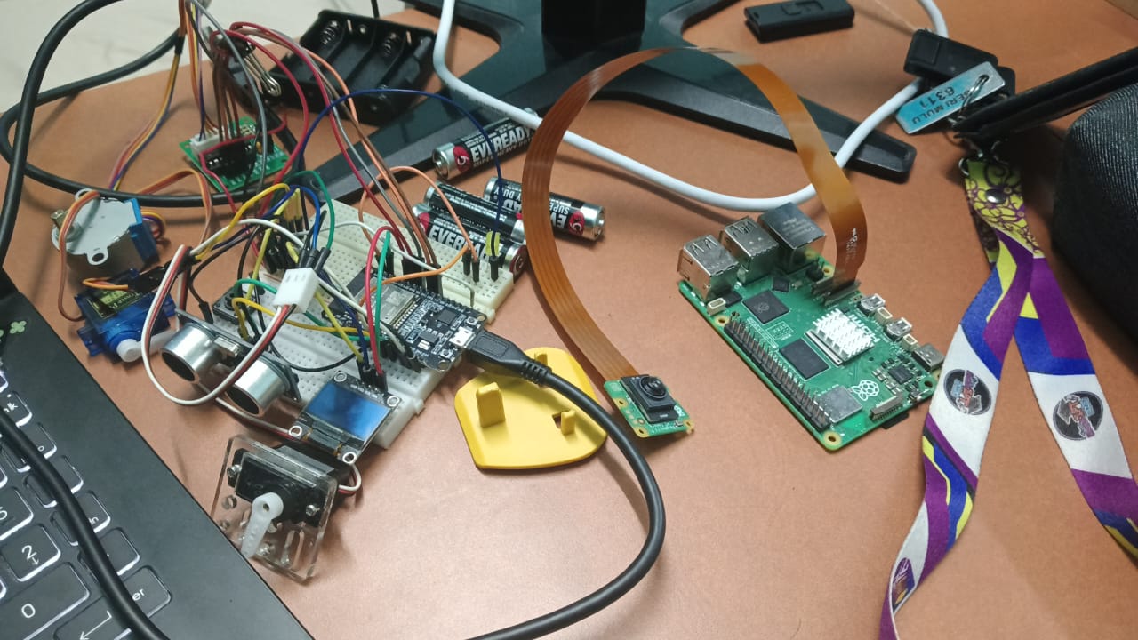 Raspberry Pi 5, ESP32, servo motors and camera module on a workbench